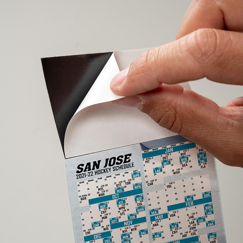 Peel and stick top on a hockey schedule, peeling off the protective sheet to expose the adhesive
